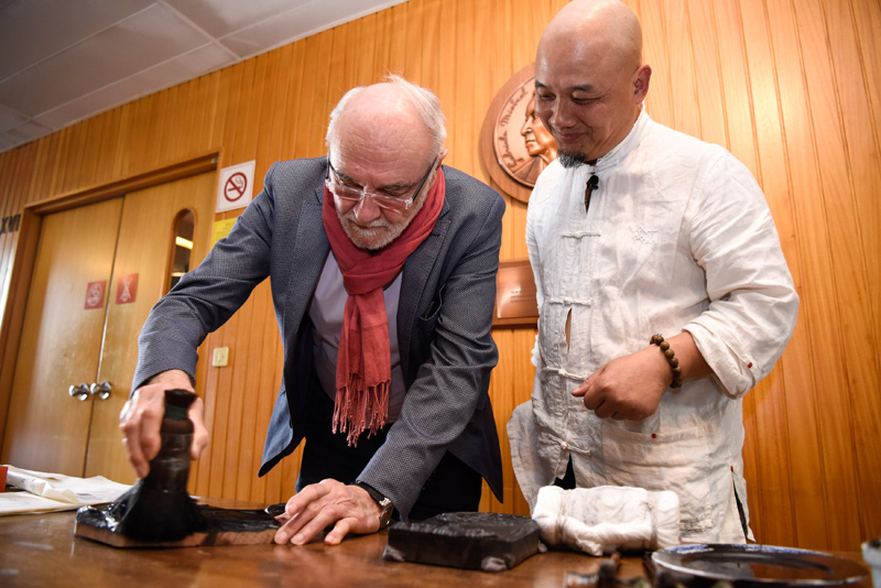 10月20日，联合国教科文组织官员（左）在法国巴黎体验“木版水印”技艺。
